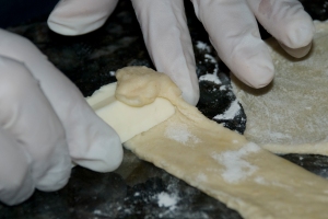 Roll the cheese with the strips of dough